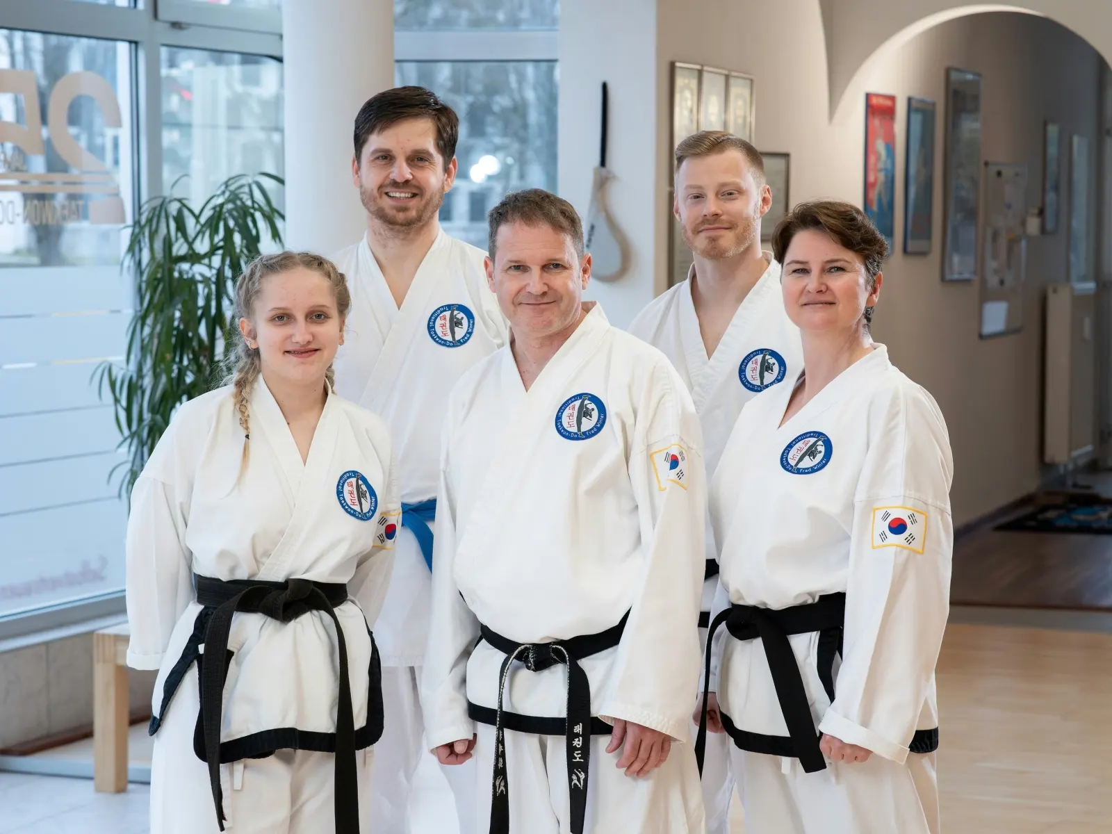 Das Trainerteam in weißen Taekwon-Do-Anzügen mit schwarzen Gürteln